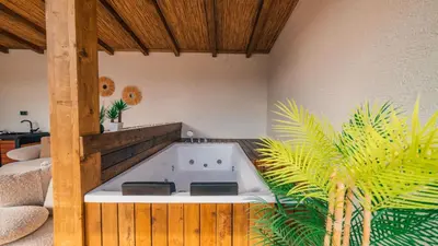 a jacuzzi tub in a room with a palm plant at The Now Sapanca Suites in Sapanca