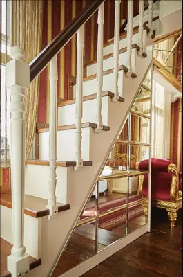 a staircase with white railings and a red chair at Sultan Suites Hotel in Istanbul