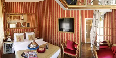 a bedroom with a bed and a tv on a wall at Sultan Suites Hotel in Istanbul