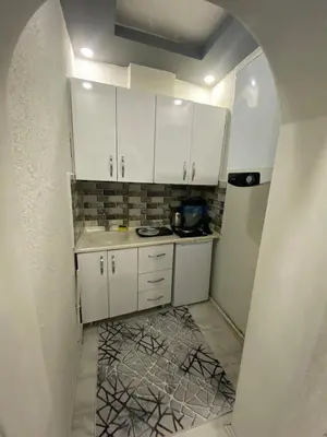 a small kitchen with white cabinets and a tile floor at Suit 2 in Bursa