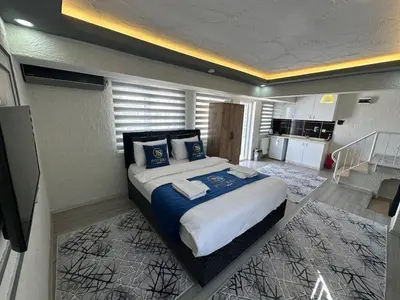 a bedroom with a large bed and a kitchen at Poyraz suit in Bursa