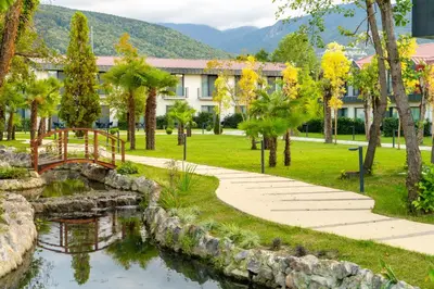 a garden with a bridge over a pond in front of a building at Wellwood Otel in Sapanca