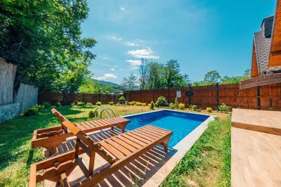 a pool with two wooden benches next to a fence at Sapanca Grandwooden Deluxe in Sapanca
