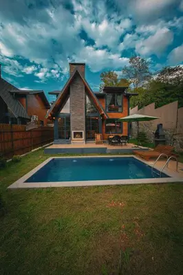 a house with a swimming pool in front of a house at Sapanca Grandwooden Deluxe in Sapanca