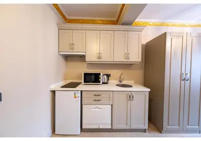 a small kitchen with white cabinets and a microwave at Taksim Studio Apart in Istanbul