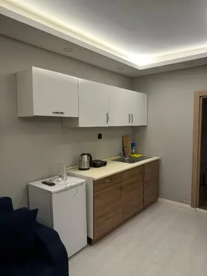 a kitchen with white cabinets and a white refrigerator at Cihangir Galataport Hotel in Istanbul
