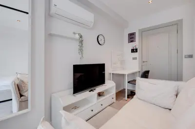 a white living room with a tv and a couch at Newly Constructed in Kadikoy Quake-Resistant-AC in Istanbul