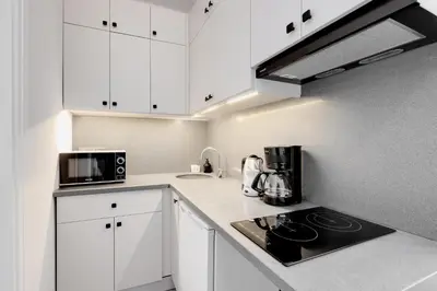 a small kitchen with white cabinets and a microwave at Newly Constructed in Kadikoy Quake-Resistant-AC in Istanbul
