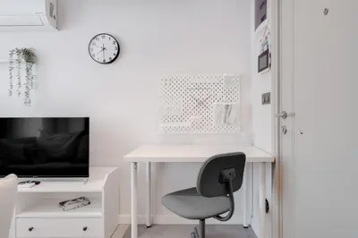 a white desk with a chair and a tv at Newly Constructed in Kadikoy Quake-Resistant-AC in Istanbul