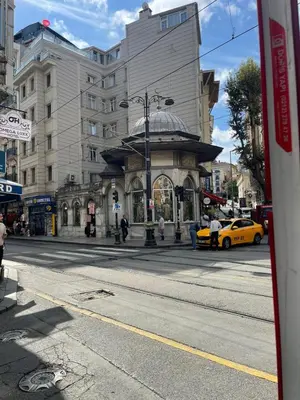 a building on a city street with a yellow taxi at Mery Hotel İstanbul in Istanbul