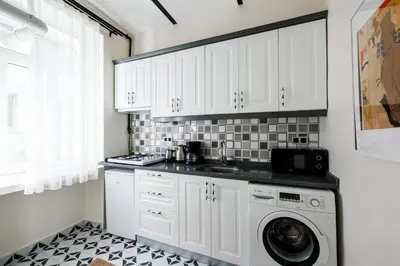 a kitchen with white cabinets and a washing machine at Lovely City Apartment Steps Away from Galata Tower in Istanbul