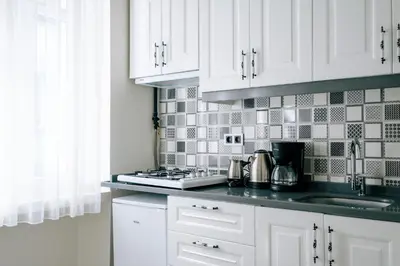 a kitchen with white cabinets and a counter top at Lovely City Apartment Steps Away from Galata Tower in Istanbul