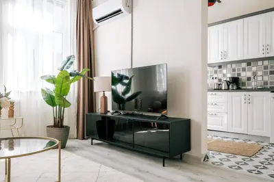 a living room with a flat screen tv on a entertainment center at Lovely City Apartment Steps Away from Galata Tower in Istanbul