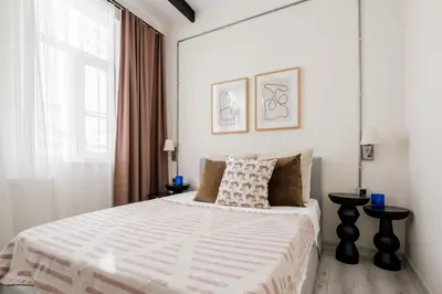 a white bedroom with a large bed and a window at Lovely City Apartment Steps Away from Galata Tower in Istanbul