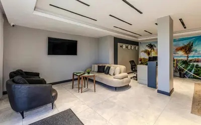 a living room with a couch and a table at AirGate Airport Hotel in Arnavutköy