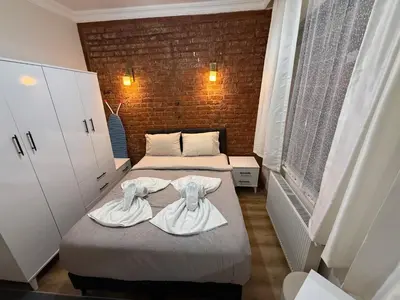two beds in a small room with towels on them at Galata Green Apple Apart in Istanbul