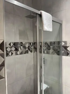 a shower with a glass door with a towel on it at Magical House Hotel in Çatalca