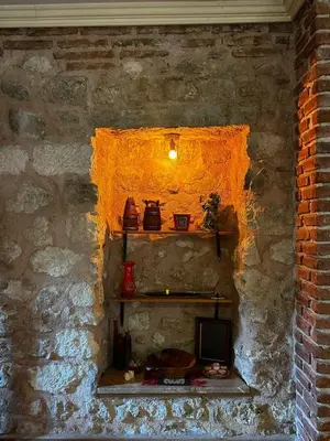 a brick wall with a shelf with pots and a television at Welcome to the presence of history! in Istanbul