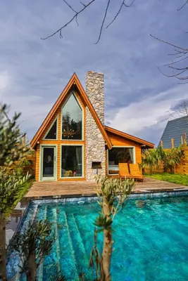 a house with a swimming pool in front of a house at Rast Sapanca Bungalov in Sakarya