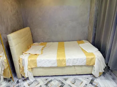 a bed with a yellow and white comforter in a room at Hilal Aparment Basement in Istanbul