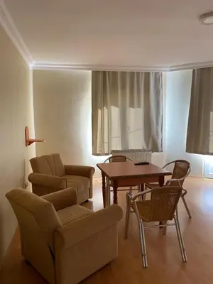 a living room with a couch and a table and chairs at Otel in Kumbağ