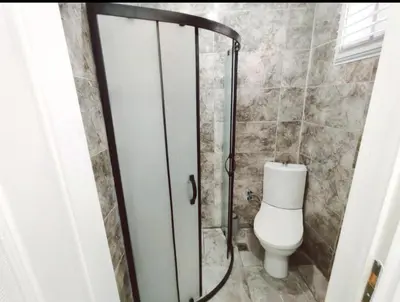 a bathroom with a toilet and a glass shower door at Ayasofya Bella Vista APART in Istanbul