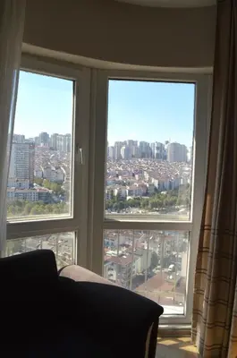 a room with three windows with a view of a city at King Suite SN20 in Esenyurt