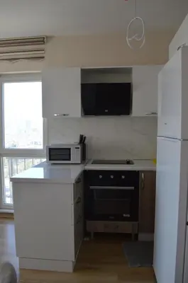 a white kitchen with a stove and a microwave at King Suite SN20 in Esenyurt