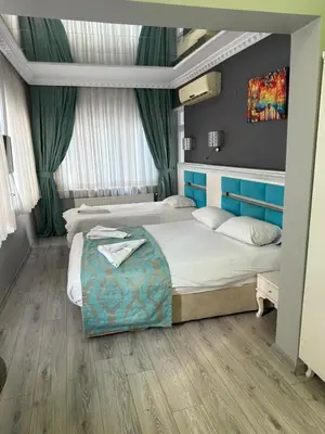 a bedroom with two beds and a painting on the wall at Holiday Suit in Istanbul
