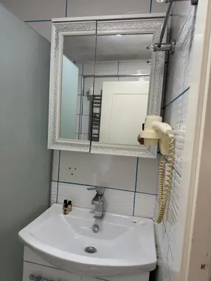 a bathroom with a white sink and a mirror at Holiday Suit in Istanbul
