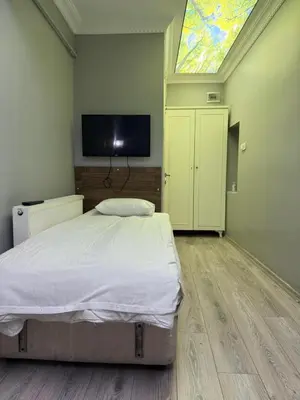 a bedroom with a bed and a tv and a window at Holiday Suit in Istanbul