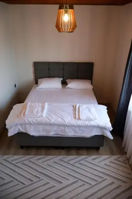 a bedroom with a large bed with white sheets at ayrıkvadi panorama in Serdivan