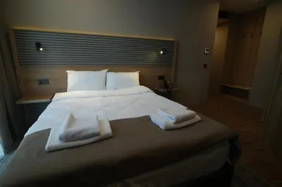 a bedroom with a large bed with two towels on it at Kent Room Hotel in Kapaklı