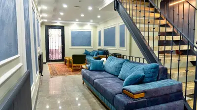a living room with a blue couch and a staircase at Miller Home's in Istanbul