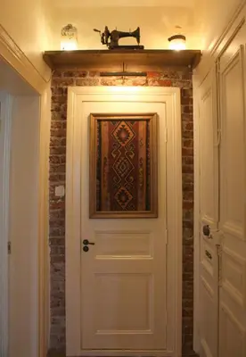a white door with a painting on it next to a brick wall at Stunning 5 Bedroom Sunlit Apartment Galata in Istanbul
