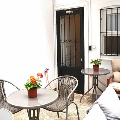 a patio with two tables and chairs and a black door at Modern apartment in the center of Kadıköy in Istanbul