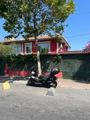 a motorcycle parked on the street in front of a house at Şişli Suites - Room42 in Istanbul