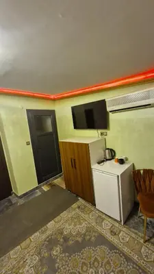 a room with a small refrigerator and a tv on the wall at Gür Star Hotel in Istanbul