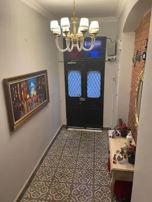 a hallway with a black door and a chandelier at Ozcans Pera Flats 8 in Istanbul