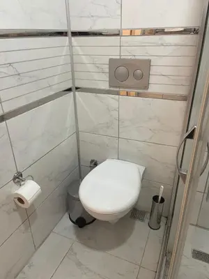 a small bathroom with a toilet with marble walls at Ozcans Pera Flats 9 in Istanbul