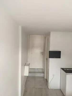 an empty white room with a hallway with a kitchen at Şişli Suites - Room46 in Istanbul