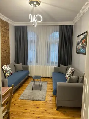 a living room with two blue couches and a table at Ozcans Sururi Pera Flats 2 in Istanbul