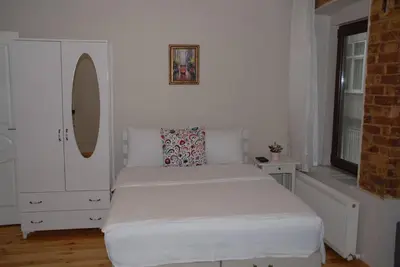 a white bedroom with a bed and a window at Ozcans Pera Sururi Flats 4 in Istanbul