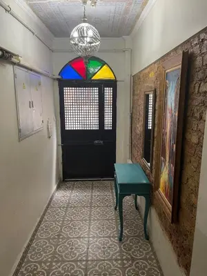a hallway with a black door and a colorful window at Ozcans Pera Sururi Flats 4 in Istanbul