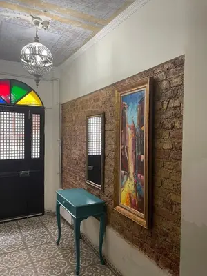 a room with a table and a painting on a brick wall at Ozcans Sururi Pera Flats 8 in Istanbul