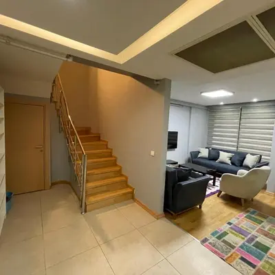 a living room with a staircase and a couch at Modern Comfort Steps from Taksim in Istanbul