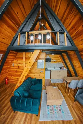 a living room of a wooden cabin with a blue couch at Hilltop Bungalov Sapanca 3 in Sapanca