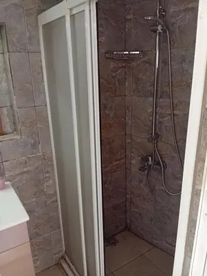 a bathroom with a shower with a glass door at As Pansiyon in Istanbul