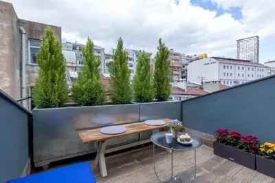 a rooftop balcony with a wooden table and plants at Lampa Design Hotel-Special Category in Istanbul