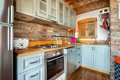 a kitchen with blue cabinets and a stove top oven at Alaattin Apartments in Istanbul